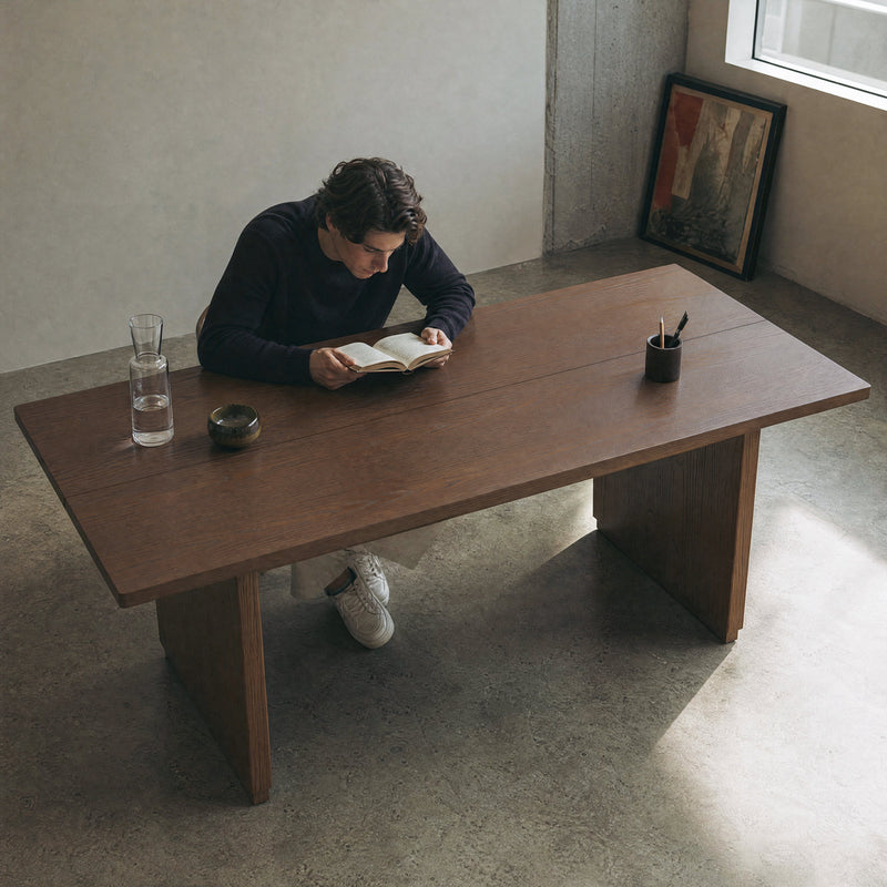 Man reading at a large wood desk in a minimalist home office